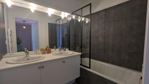 a bathroom with two sinks and a large mirror at Cozy apartment with exceptional view in Gex