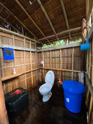 a bathroom with a toilet and a blue bucket at Sunrise Raja Ampat in Besir