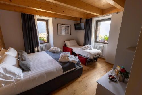 a small bedroom with two beds and two windows at Adamello skyline in Temù
