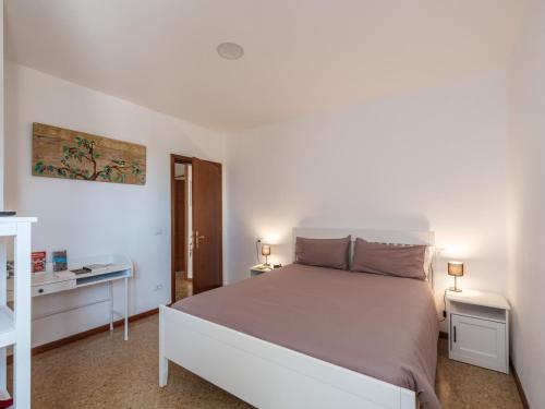 a white bedroom with a large bed and a desk at Agriturismo Le Crede 1930 in Portogruaro