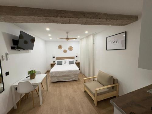 a bedroom with a bed and a table and a chair at Apartamentos Cibeles Centro Histórico in Mérida