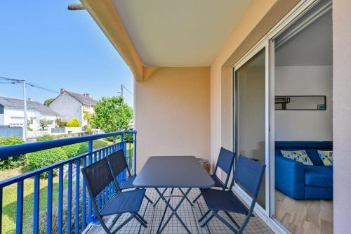 a balcony with a blue table and chairs at Le Delezir - Wifi - Balcon - Plage in Saint-Nazaire