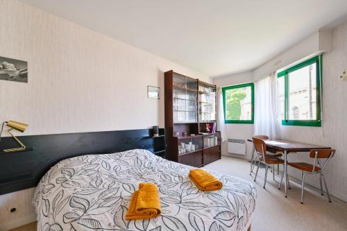 a bedroom with a bed with yellow towels on it at Le Delezir - Wifi - Balcon - Plage in Saint-Nazaire