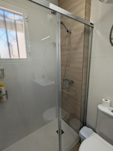 a bathroom with a glass shower with a toilet at Apartamento luminoso in Mazarrón