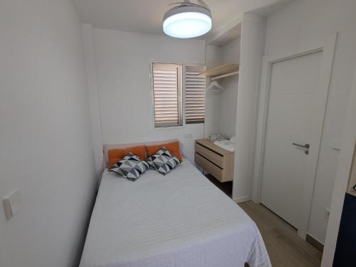 a bedroom with a bed with pillows on it at Apartamento luminoso in Mazarrón