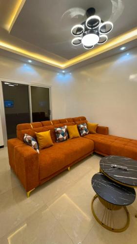 a brown couch in a living room with a ceiling at Appartement confort keur massar in Rufisque