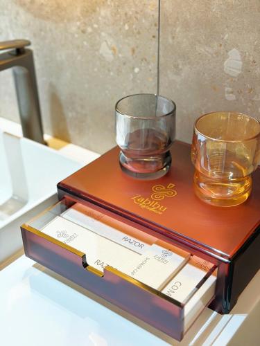 two glasses sitting on top of a wooden box at Zabibu Residence in Nkongontha