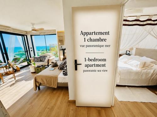 a room with two beds and a sign that reads apartment i clumpumpoperative at le lodge Saint Clair in Sète