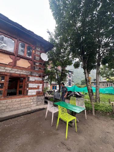 a table and chairs in front of a building at Boom Shankar in Kalgha