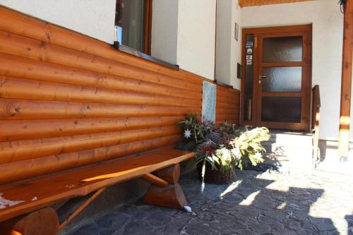 a wooden wall with a bench in front of a building at Chata Horec in Liptovské Revúce