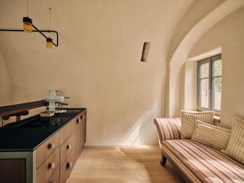a kitchen with a counter and a couch in a room at Stuveles Apartments in Brixen