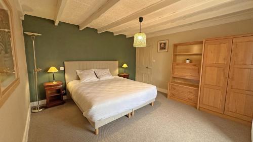 a bedroom with a white bed and wooden cabinets at Le charron in Saint-Mathieu