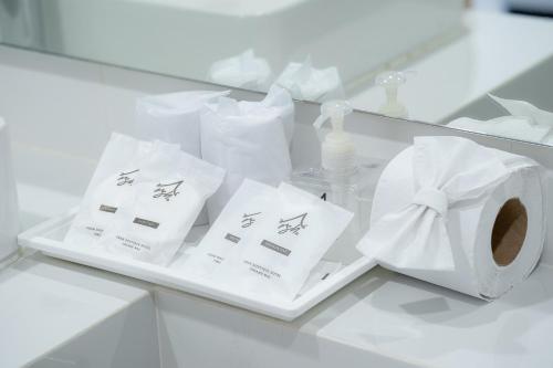 a white counter with toilet paper and a roll of tissue at Arsh Boutique Hotel in Chiang Mai