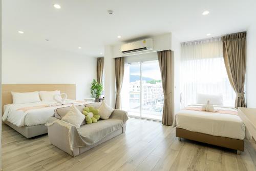 a hotel room with two beds and a couch at Arsh Boutique Hotel in Chiang Mai