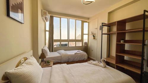 a bedroom with two beds and a window at RAFiF Pyramids View Hotel in Cairo