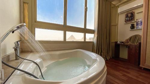 a bath tub in a bathroom with a window at RAFiF Pyramids View Hotel in Cairo