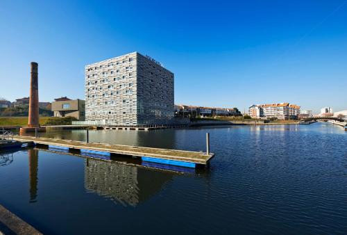 a tall building sitting on top of a body of water at Meliá Ria Hotel & Spa in Aveiro