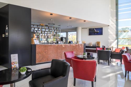 a restaurant with tables and chairs and a bar at Meliá Ria Hotel & Spa in Aveiro