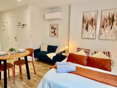 a living room with a bed and a table at Le Cocon d'Or - Hyper centre - Clim - WIFI in Toulouse