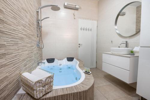 a bathroom with a tub and a sink at Villa Glory in Even Menahem