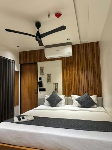 a bedroom with a large bed with a ceiling fan at Hotel the Infinity in Rajkot