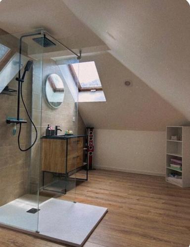 a bathroom with a glass shower in a attic at L'instant Cosy in Gamaches