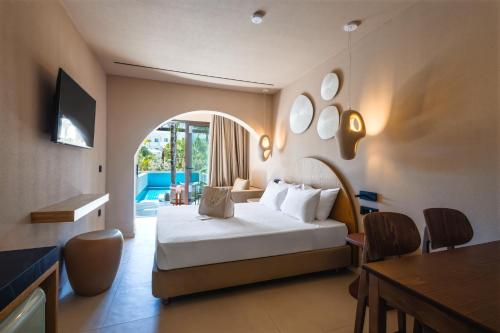 a hotel room with a bed and a table and chairs at Palmea Suites in Pefki