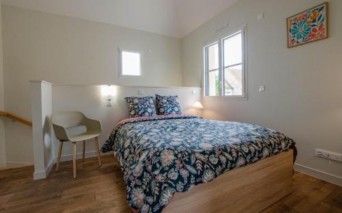 a bedroom with a bed and a chair and a window at Numéro 1 in Morvilliers