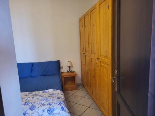 a bedroom with a blue bed and a wooden door at Villa Sunny Side - Panoramic View in Costa Paradiso