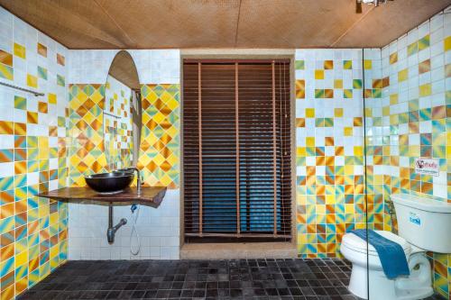 a bathroom with a toilet and a bowl on a table at Cozy Beachfront Samroiyod in Baanphakrimlay 