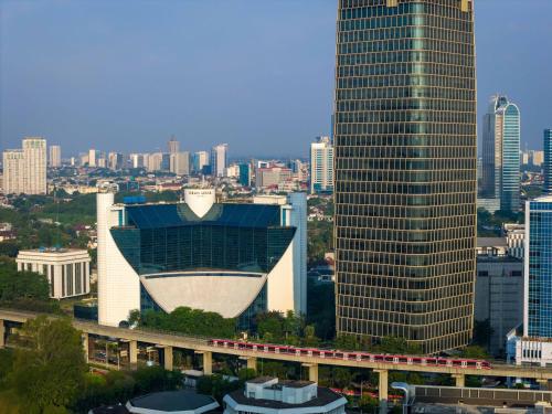 a city skyline with a train in front of buildings at Gran Meliá Jakarta in Jakarta