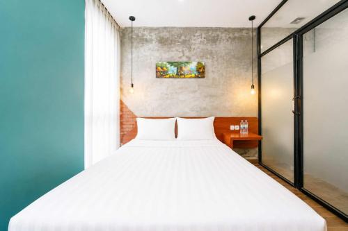 a bedroom with a large white bed and a window at Noesa Heritage in Surabaya