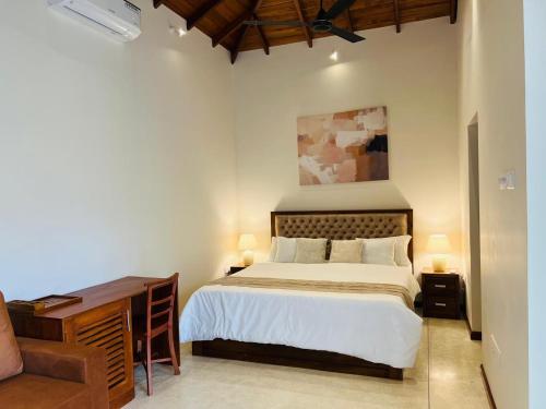 a bedroom with a bed and a dresser and a desk at Eden Collection Thalpe in Talpe