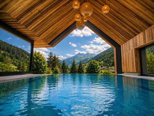 ein Pool in einem Haus mit Blick auf die Berge in der Unterkunft Forster's Naturresort in Neustift im Stubaital