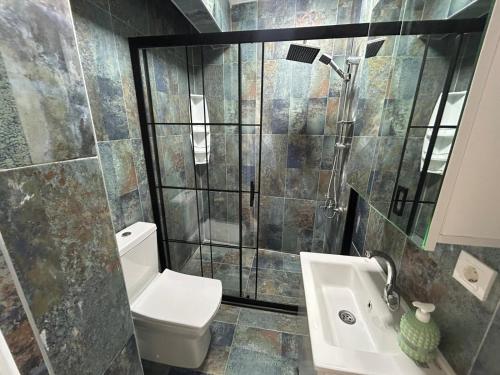 a bathroom with a toilet and a shower and a sink at BEYAZEV Apart in Erdek