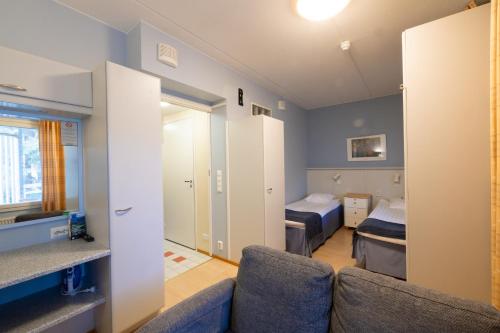 a living room with a couch and a bedroom at Spa Hotel Rauhalahti in Kuopio