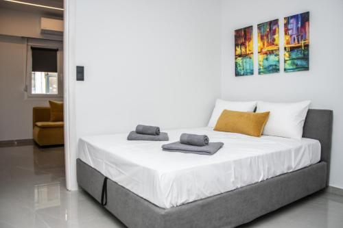 a bedroom with a large white bed with towels on it at COMFY Apartments in Alexandroupoli