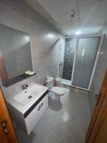 a white bathroom with a sink and a toilet at Apartment Selouane in Selouane