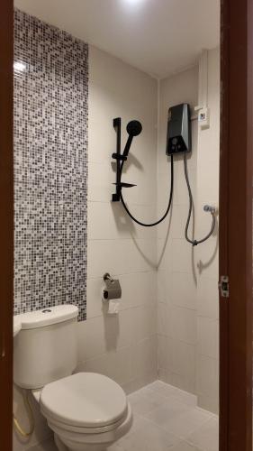 a bathroom with a toilet and a tv on the wall at Shwe Ooe Lay Guest House 2 in Pratunam