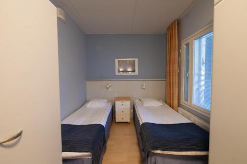 two beds in a room with blue walls at Spa Hotel Rauhalahti in Kuopio