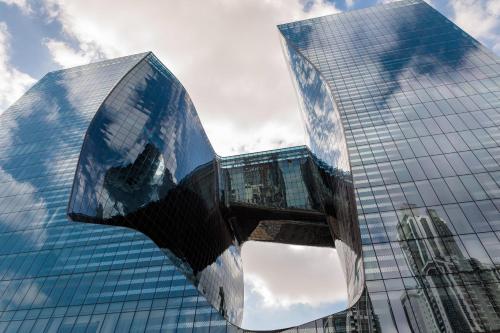 a tall glass building with its reflection in front of it at ME by Meliá Dubai Residences in Dubai