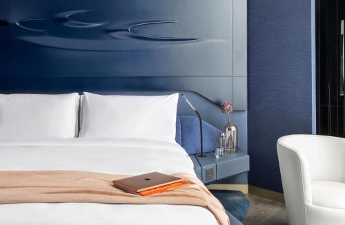 a bedroom with a bed with a book on it at ME by Meliá Dubai Residences in Dubai