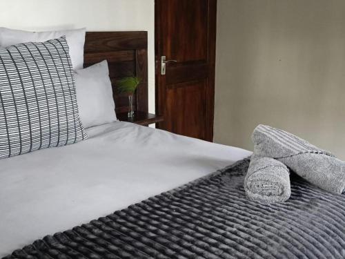 a bed with two pillows and two towels on it at Ukutula Resort in Dullstroom