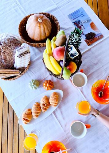 a table with fruits and vegetables and bread and orange juice at Tholos Alexandra's Beachfront House in Kavoúsion