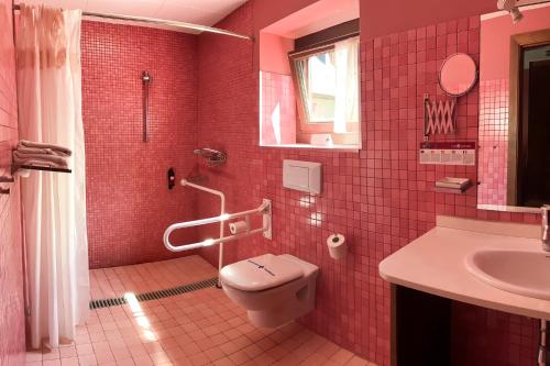 a pink bathroom with a toilet and a sink at Hotel Casa Estampa in Escuñau
