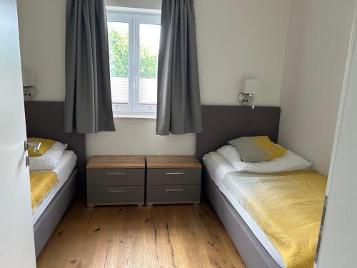 two beds in a small room with a window at Reusenhaus Nord in Breege
