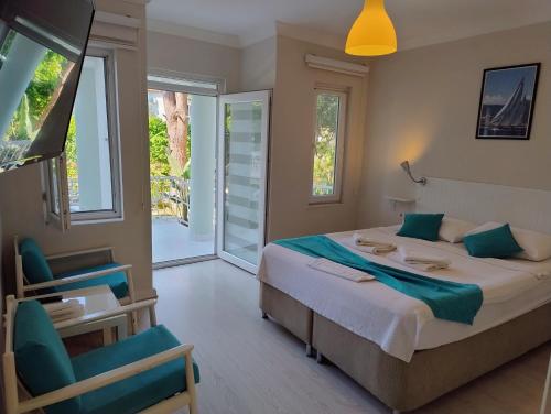 a bedroom with a large bed and a balcony at Göcek Selya Hotel in Göcek