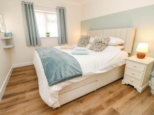 a bedroom with a large white bed and a window at The Old Post Office in Ventnor