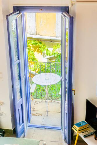 an open door with a table on a balcony at Kali Strata 2 - Downtown in Symi