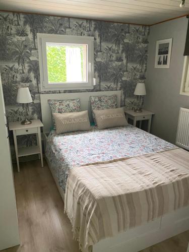 a bedroom with a bed with two tables and a window at Chez Nanou in Marmagne
